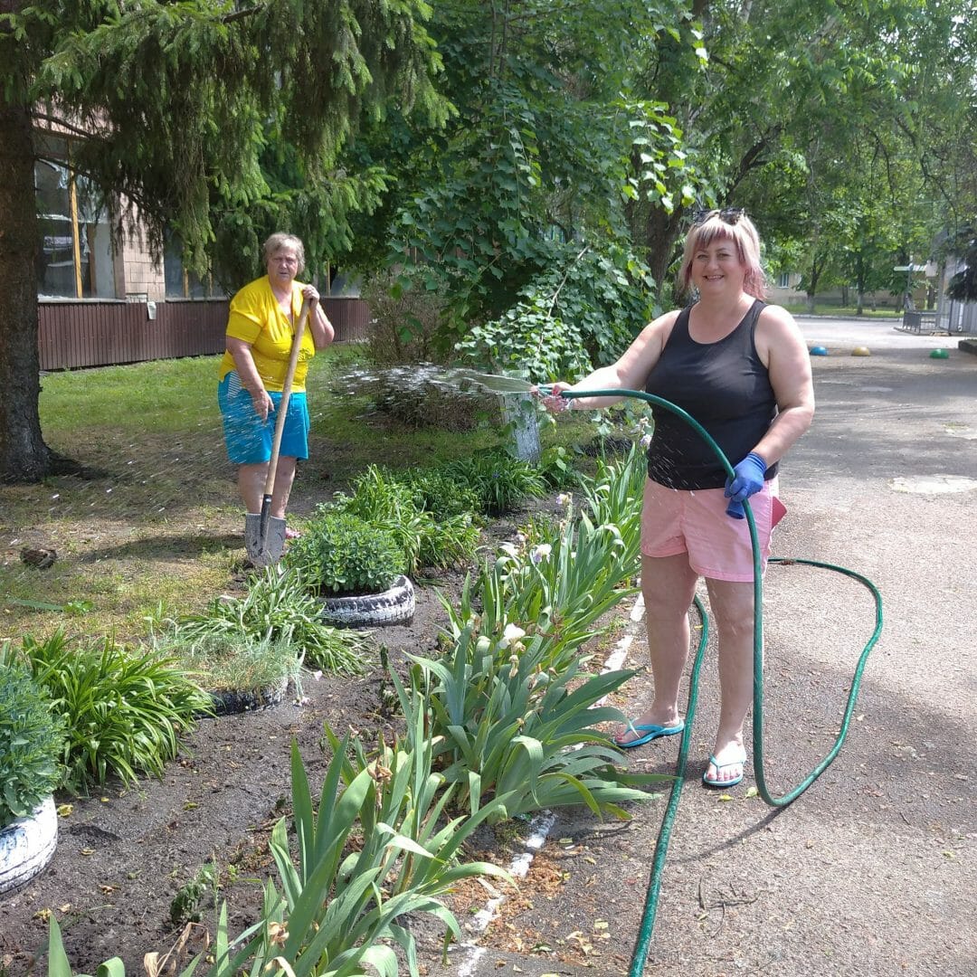 Local municipal services workers planting flowers in parks and along sidewalks.   