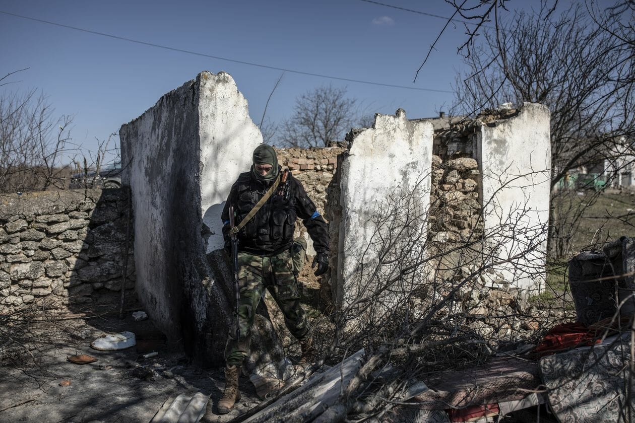 A Ukrainian military examines the ruins of the building where the occupation troops were stationed. 