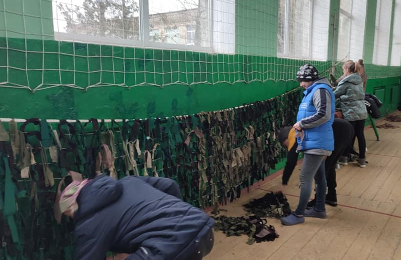 Residents of the Vakulove community weaving camouflage nets