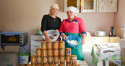 Olena Umanska and Olena Khomenko prepare canned fish