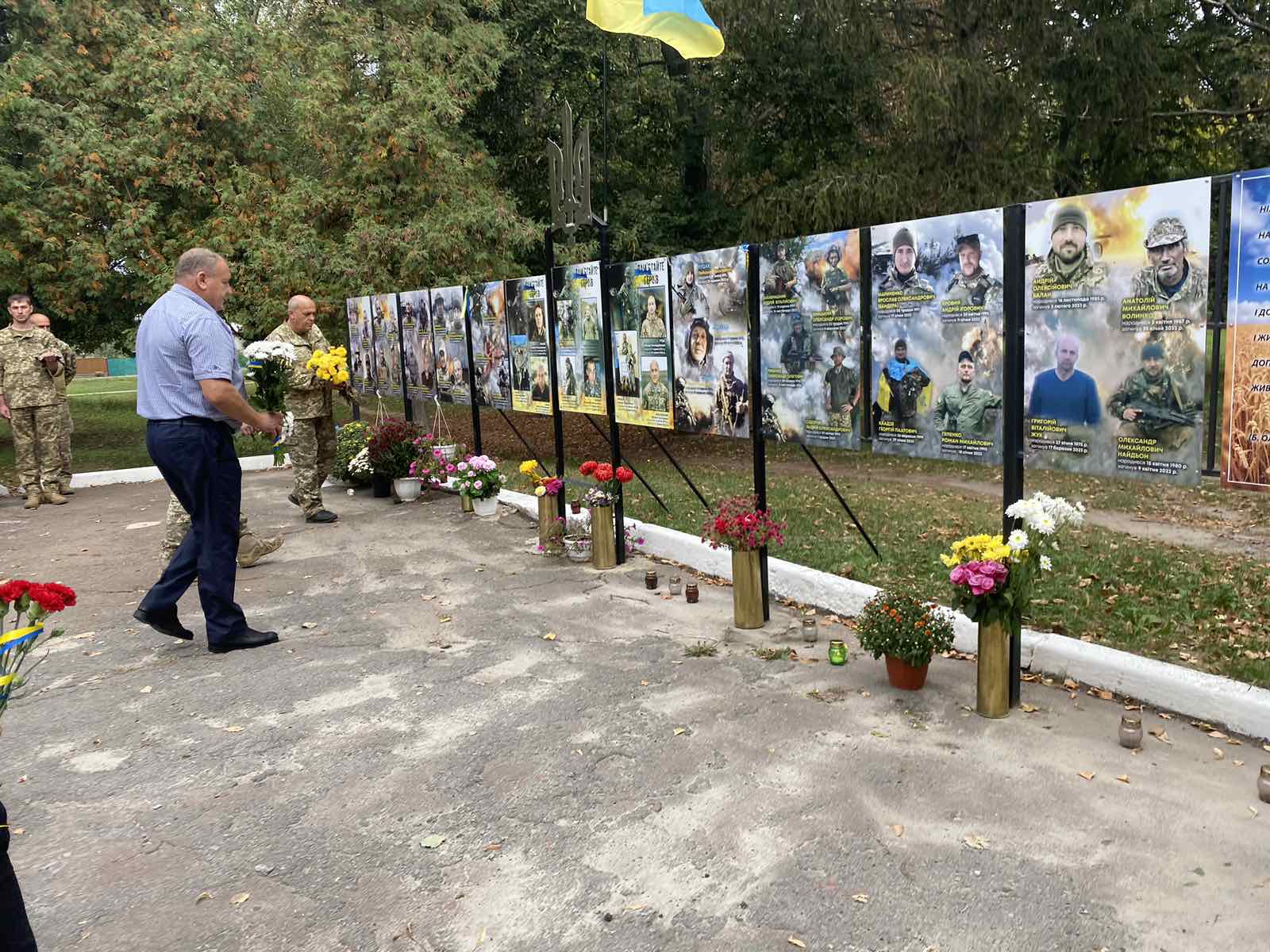 Laying flowers at the memorial sign of defenders of Ukraine