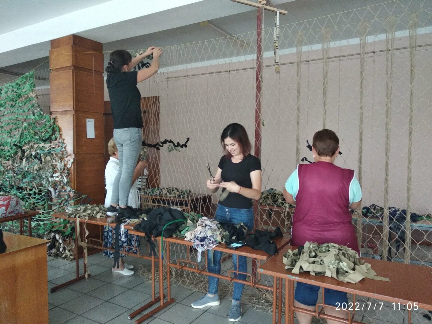 Community volunteers weaving camouflage nets