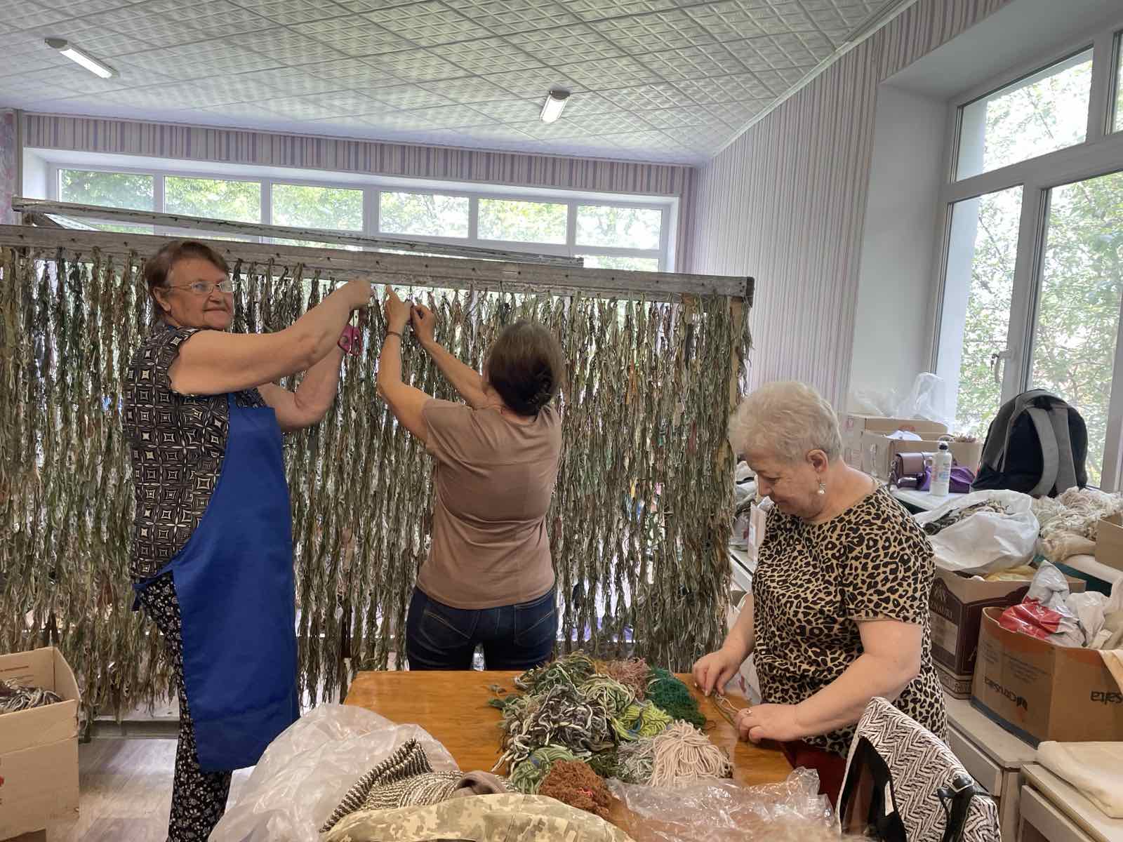 A team of women volunteers making camouflage netsA team of women volunteers making camouflage nets