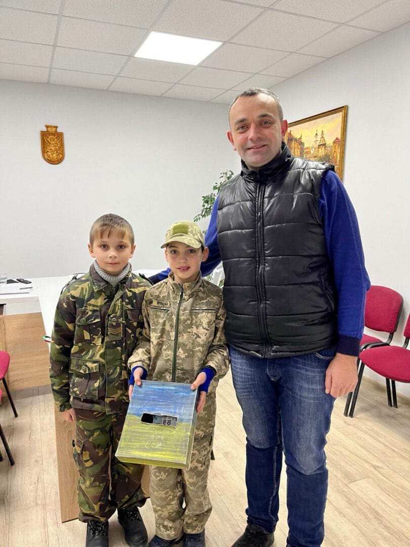 Community leader Petro Sokolovskyi with 10-year-old boys who organized raised funds for the Armed Forces of Ukraine at their own checkpoint