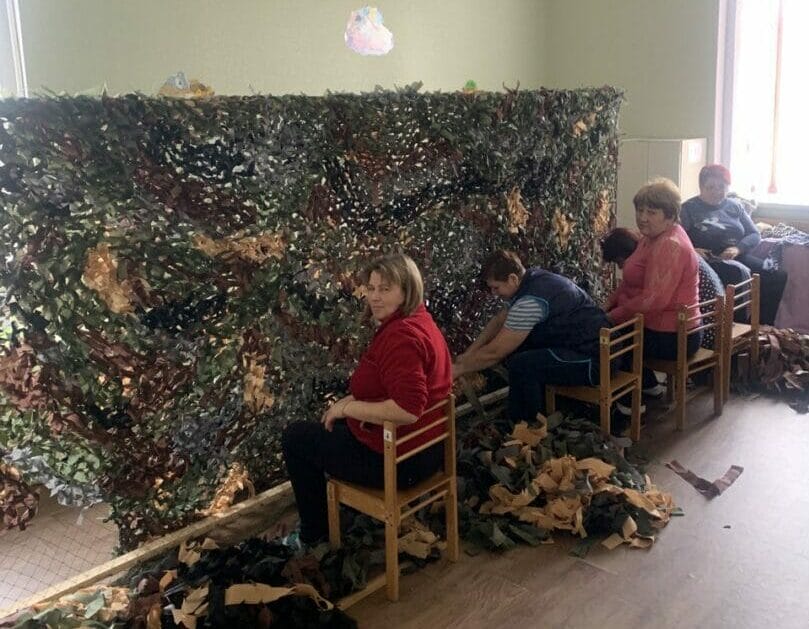 Employees of the Settlement Council weaving camouflage nets