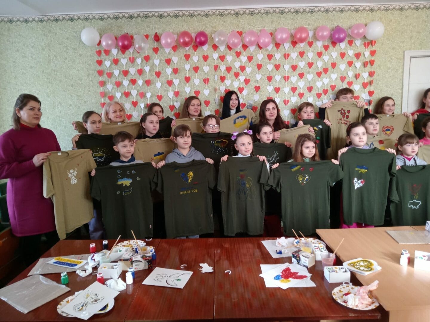 Pupils of the children’s music school holding hand-painted t-shirts for defenders