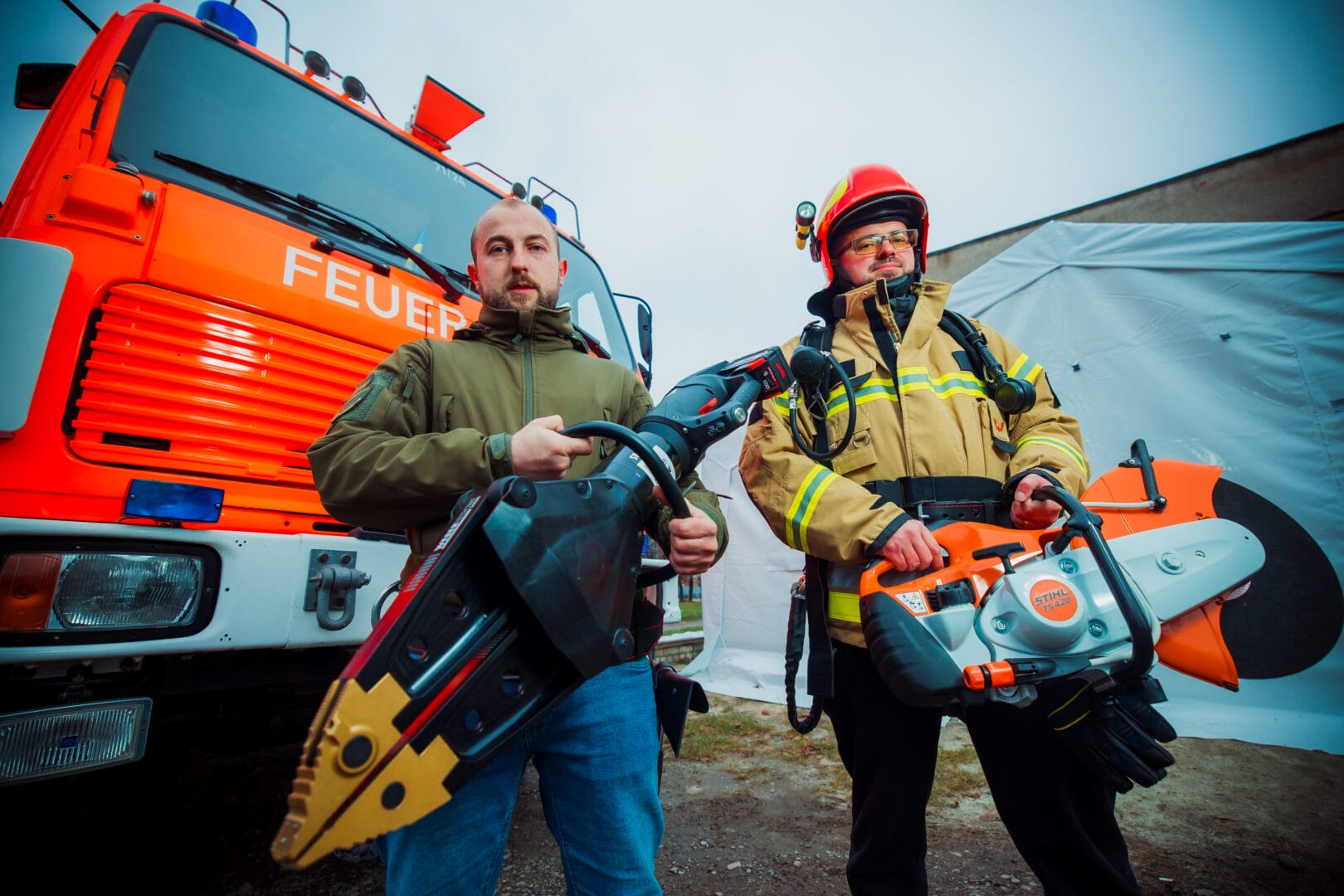 Members of the Volunteer Fire Brigade with equipment on the background of an insulated tent 