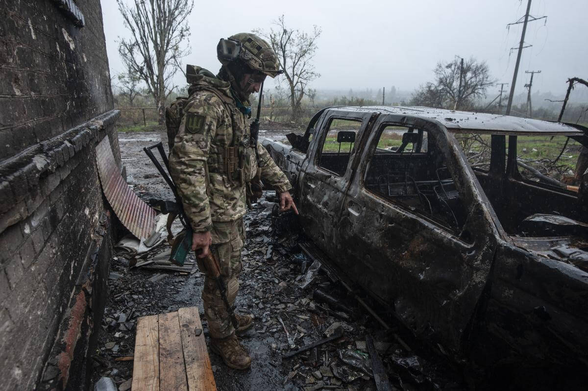A fighter with the call sign “The Thirteenth” shows an unexploded mine next to a burned-out car. November 2022