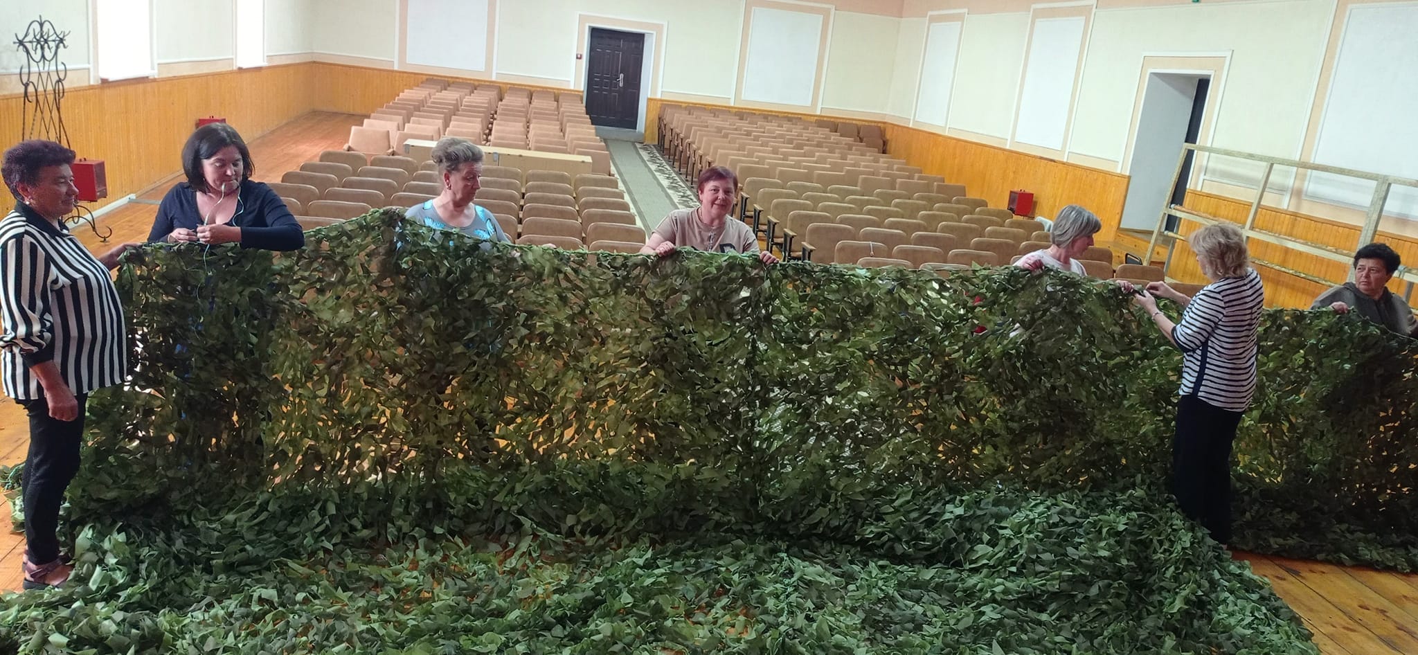 In the photo, employees of cultural and educational institutions and community volunteers weave nets for military personnel