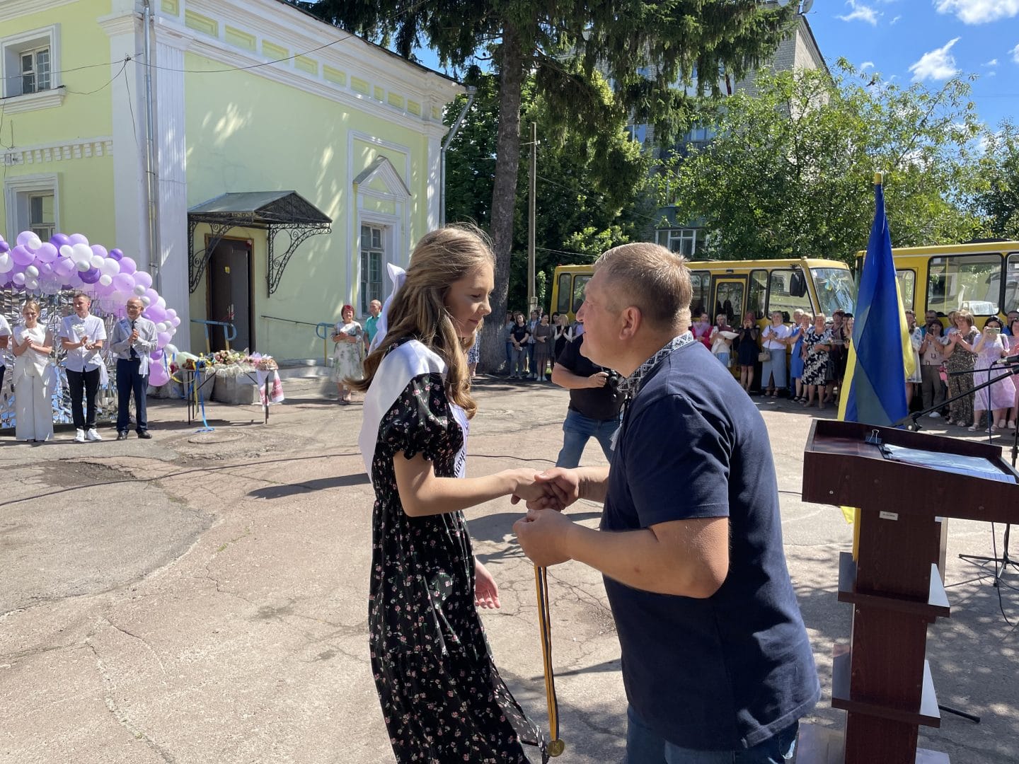 Esman Settlement Head Serhii Minakov presents a medal to a graduate of 2024