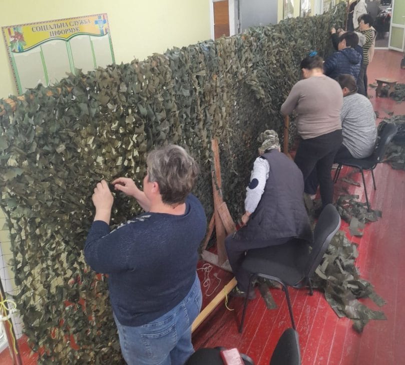 Villagers weaving camouflage nets for the military