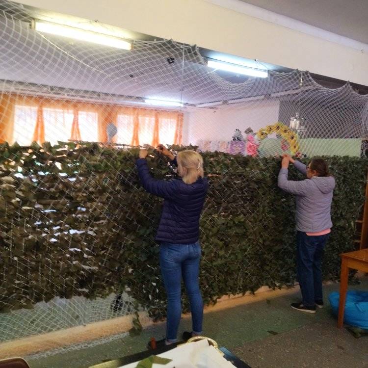 Volunteers weaving camouflage nets