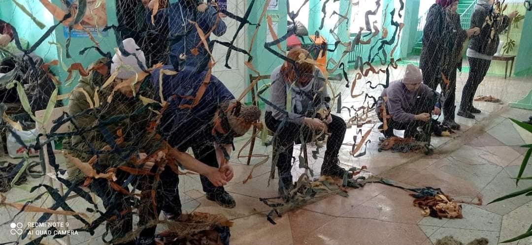 The volunteer team weaving camouflage nets for the military