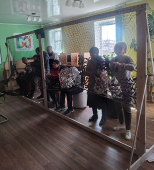 Library staff weaving camouflage nets 