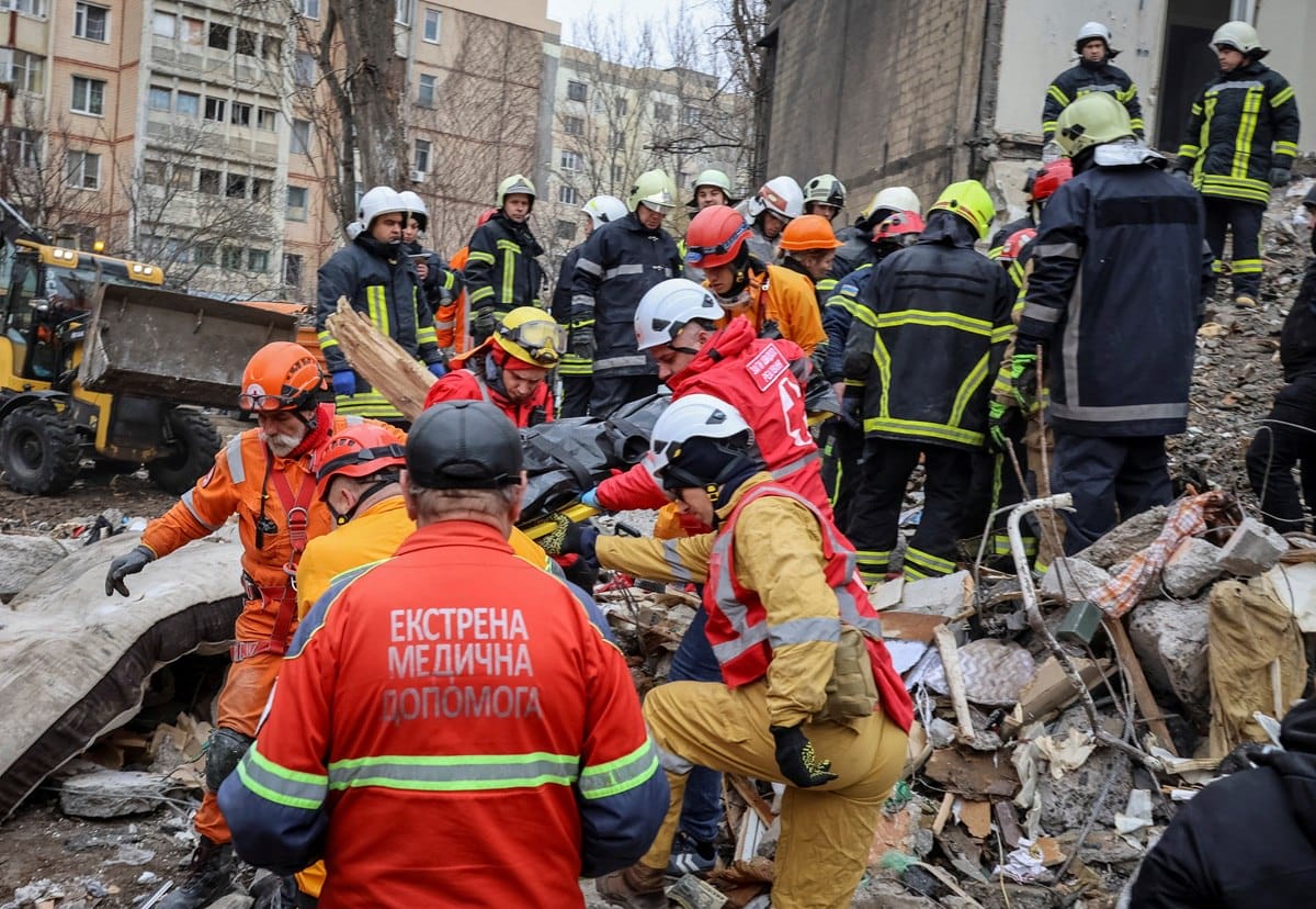 Rescue teams freeing people from rubble after a drone attack