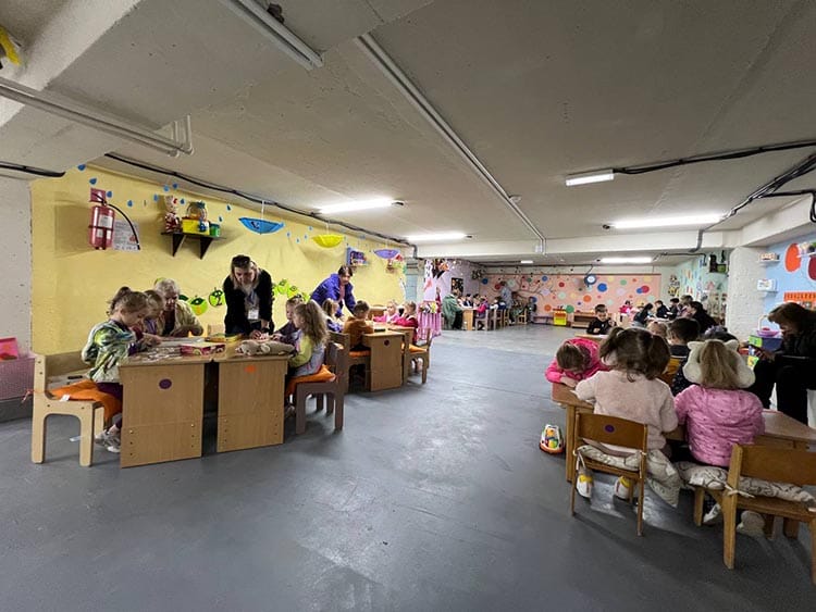 Children studying in a bomb shelter during an air raid