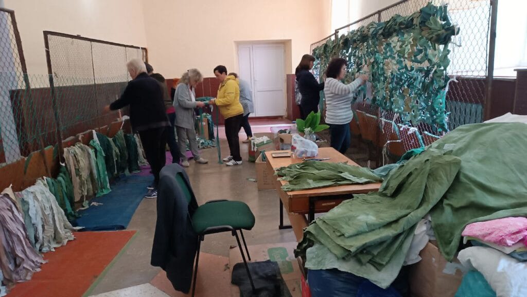 Craftswomen in the House of Culture weaving camouflage nets.
